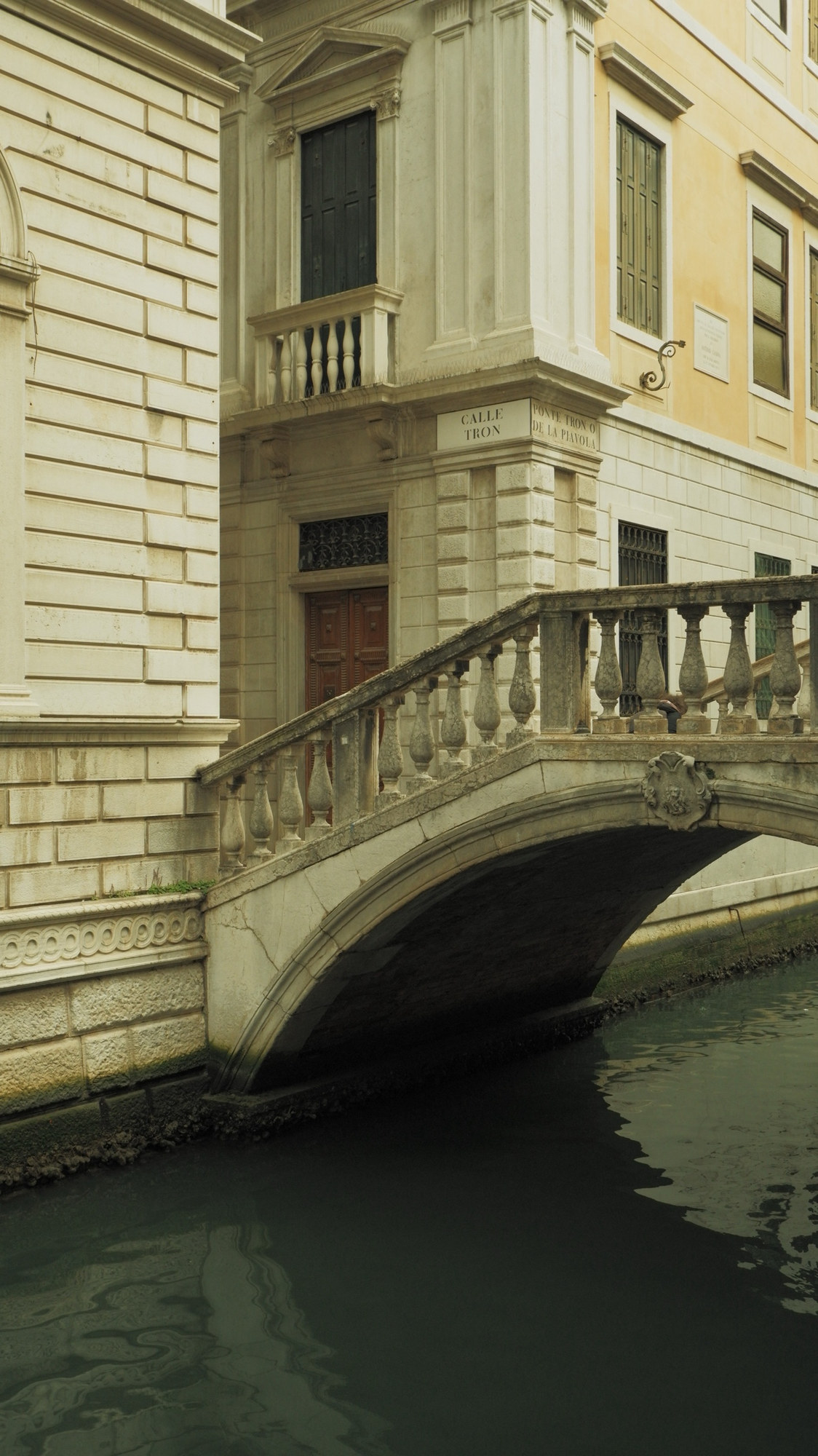 A stone bridge beside a corner signed Calle Tron